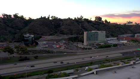 Morning-commute-traffic-on-San-Diego-interstate-8-and-Hilton-Hotel,-aerial-flyby