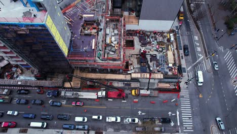 Vista-Aérea-Frente-A-Un-Sitio-De-Construcción-En-Queens,-Ciudad-De-Nueva-York---Inclinación,-Disparo-De-Drones