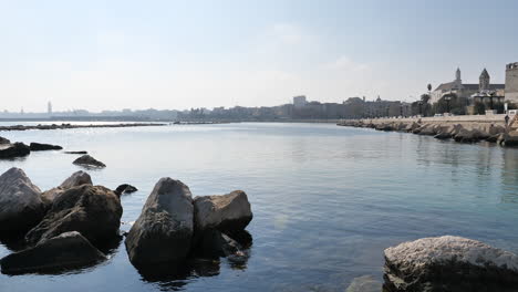 Waterfront-of-Lungomare-Imperatore-Augusto-with-fishermen-in-Bari,-Italy-with-panning