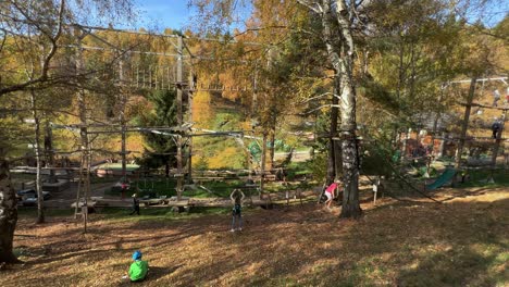 Familias-Divirtiéndose-Con-Un-Puente-De-Cuerda-Suspendido-En-La-Estructura-De-Madera-Del-Parque-De-Aventuras