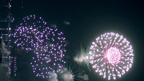 Fireworks-display-celebration-for-New-year's-eve-with-abstract-multicolor-big-shining-glowing-fireworks-show-with-bokeh-lights-in-the-night-sky