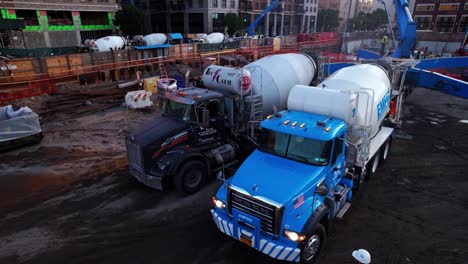 Aerial-view-around-cement-mixers-filling-concrete-pumps-at-a-building-site-in-NY