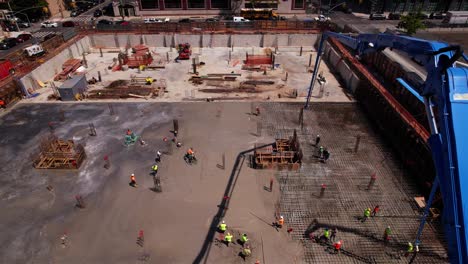 Menschen,-Die-Im-Ersten-Stock-Einer-Projektbaustelle-Arbeiten---Rückwärtsfahrt,-Neigung,-Luftaufnahme