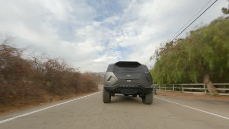 Folgen-Sie-Mir,-Aufnahme-Eines-Atemberaubenden-Offroad-Autodesigns,-Das-Auf-Einer-Ländlichen-Straße-Beschleunigt