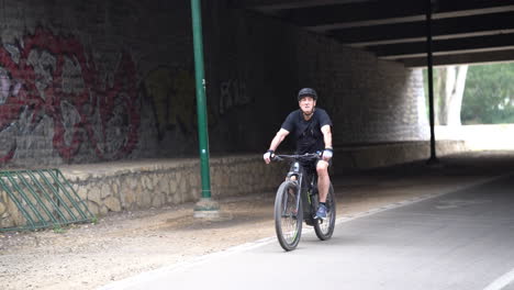 Tel-Aviv-Israel-nov-11-2022:-An-elderly-man-rides-a-bicycle-under-a-bridge-at-haYarkon-park-Tel-Aviv-Israel