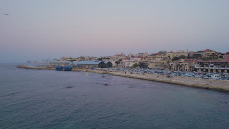 Langsamer-Drohnenschuss-Vor-Dem-Alten-Hafen-Von-Jaffa,-Der-Bei-Sonnenuntergang-Mit-Menschen-überfüllt-Ist