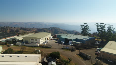 Drone-reveal-over-industrial-warehousing-and-factories-in-South-Africa-with-the-valley-of-the-thousand-hills-in-the-background