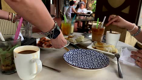 Comidas-De-Mesa-Con-Manos-De-Mujer,-Platos-Y-Tazas-De-Café-En-La-Mesa-Y-Sin-Rostro