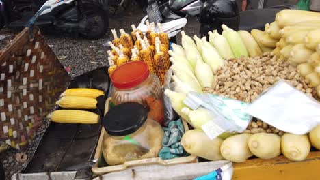 Maíz-Tostado-Y-Cacahuetes-Vendedor-Ambulante-De-Comida-En-Indonesia-Bali-Asa-Un-Plato-De-Bocadillos-En-La-Playa-De-Saba,-Asado,-Gianyar,-Cocina-Tradicional-Del-Sudeste-Asiático