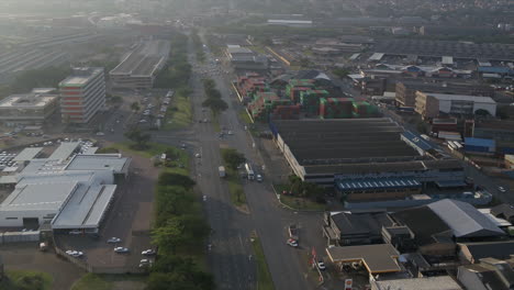 Wide-drone-aerial-through-an-industrial-area-of-Durban,-South-Africa-with-warehousing,-factories-and-shipping-container-yards