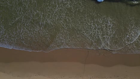 Top-Down-Blick-Entlang-Des-Strandufers-Von-Falesia,-Wellen,-Die-Im-Sand-Krachen,-Portugiesisches-Reiseziel