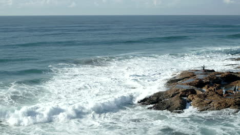 Drone-aerial-over-a-man-standing-on-the-rocks-fishing-In-the-Indian-Ocean-South-Africa