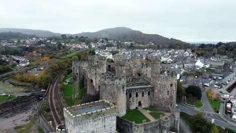 Historic-Conwy-castle-aerial-view-of-Landmark-town-ruin-stone-wall-battlements-tourist-attraction-slow-push-in