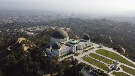 Toma-Aérea-Del-Observatorio-Griffith-Con-El-Horizonte-De-Los-ángeles-Al-Fondo