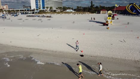 Drohnenaufnahme-Eines-Mannes,-Der-An-Einem-Strand-Steht-Und-Die-Landschaft-Enthüllt