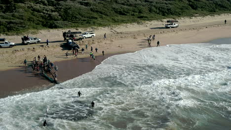 aerial-drone-of-Commercial-fishing-company-dragging-nets-with-Sardines-and-pilchards-onto-shore