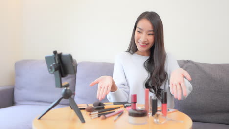 Asian-Female-Beauty-Influencer-Recording-Make-up-Tip-Videos-Using-a-Smartphone,-for-her-blog