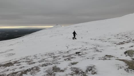 Eine-Person-Wandert-Mit-Zwei-Kleinen-Hunden-In-Einer-Verschneiten,-Arktischen-Landschaft