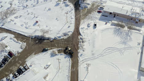 Aerial-Directly-Above-Tractor-on-Working-Farm-in-Snowy-Conditions-in-California,-United-States