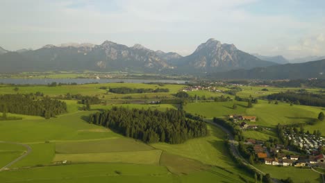Eine-Rückwärts-Fliegende-Drohne-Zeigt-Ein-Kleines-Dorf-Im-Ländlichen-Bayern,-Deutschland