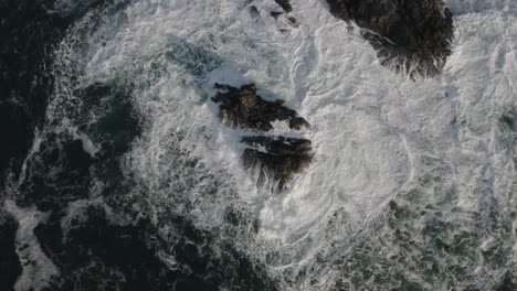 Drone-shot-of-waves-hitting-a-rock-in-the-Pacific-Ocean-off-the-coast-of-Vancouver-Island,-British-Columbia