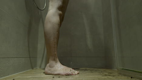 Schmutzige-Weibliche-Füße,-Die-In-Einer-Laufenden-Duschkabine-Stehen