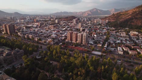 Parque-forestal-glowing-sunrise-Santiago-city-buildings-and-streets-metropolis-over-skyscrapers-under-Andes-mountains