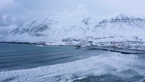 Atemberaubende-Landschaft-Der-Stadt-Ólafsfjörður-In-Nordisland-Und-Die-Arktischen-Ozeanwellen---Luftaufnahme