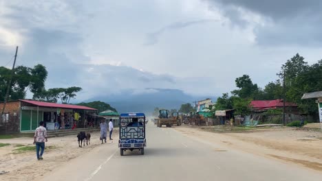 Countryside-road-with-chaotic-traffic-and-small-village-in-Bangladesh,-POV