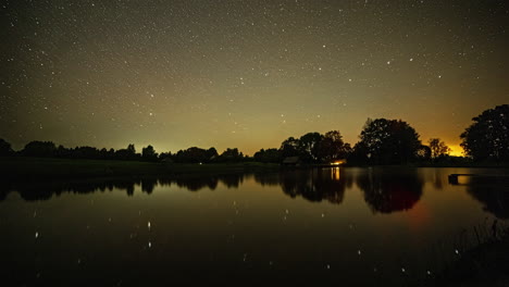 Time-lapse-of-stars-in-starry-sky-reflecting-over-lake-water-surface-at-sunrise