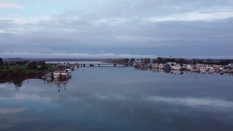 Aerial-Shot-of-Bridge-over-River-with-Fisher-Village,-Ladner-BC