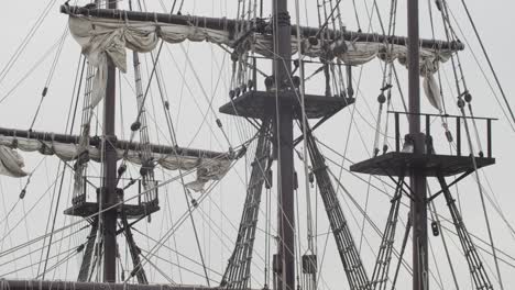 Galleon-Andalucia-replica-ship-detail-steady-shot-of-foremast,-mainmast-and-mizzenmast-with-sails,-ropes-birds-flying-by-while-docked-in-Valencia-in-slow-motion-60fps