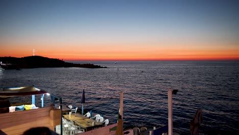 Romantic-Dinner-Scene-of-Oceanside-Restaurant-and-Mediterranean-Sunset