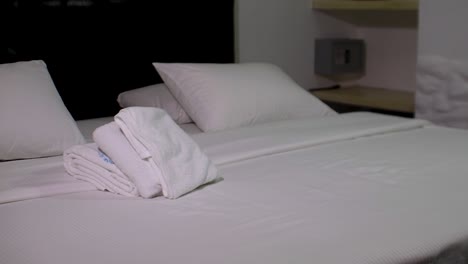 Hostal-Sauberes-Schlafzimmer,-Weiße-Bettwäsche-Und-Handtücher-Und-Safe,-Nahaufnahme,-Pfanne-Rechts