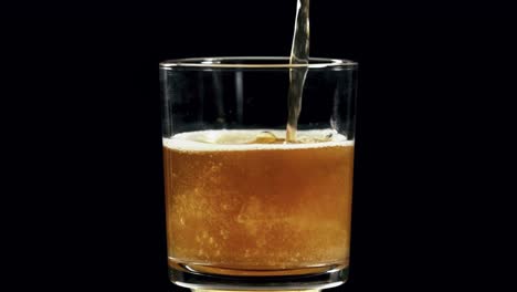 Pouring-Beer-Into-Glass-In-Slow-Motion-With-Plain-Black-Background---close-up,-180fps