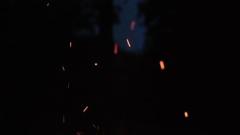 Stoking-fire-with-embers-and-sparks-in-slowmotion