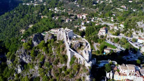 Flying-over-the-castle-of-Gilette,-typical-village-in-south-of-france,-with-houses-and-trees-around