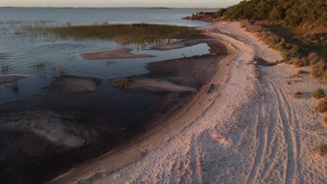 Photographer-on-lake-shore-at-sunset,-Laguna-Negra-in-Uruguay