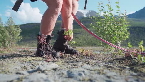 Cropped-Shot-Of-Male-Hiker's-Legs-With-A-Dog,-Removing-His-Boots-And-Socks-Taking-A-Break-From-A-Long-Trail-Walk-At-Anderdalen-National-Park,-Senja,-Norway
