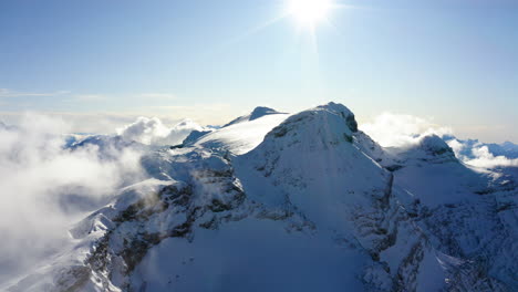 Luftschwenk-über-Hochalpine,-Schneebedeckte-Gipfel,-Die-Teilweise-Von-Nebelschwaden-Verdeckt-Werden
