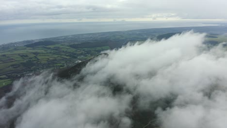 Aerial-view-of-mountain-peak-in-clouds-against-blue-sky