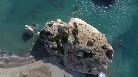 Top-down-rising-shot-over-Aphrodite's-Rock-also-known-as-Petra-Tou-Romiou-in-Pafos,-Cyprus-in-Greece