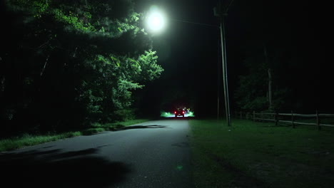 Pick-up-truck-traveling-along-eerie-countryside-road-at-night