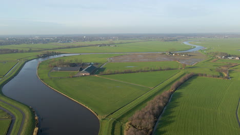 Aerial-view-of-farms-in-rural-meadows-near-a-river-in-Dutch-countryside