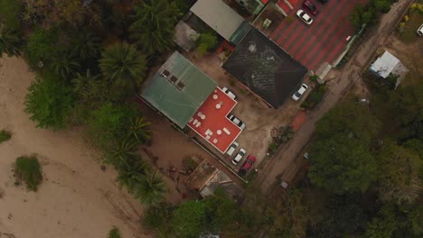 Epic-revealing-aerial-of-a-small-beach-house-with-fishing-boats-at-the-banks-of-the-nearby-river-at-this-turtke-watching-site-in-Grande-Riviere,-Trinidad