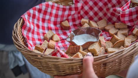 Hand-takes-crouton-canapes-served-in-basket-and-red-checkered-placemat
