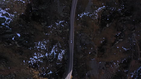 Downward-angle-drone-footage-of-a-vehicle-on-the-Susten-Pass-in-the-Swiss-Alps-in-Switzerland