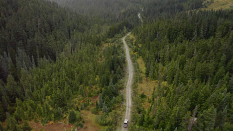 Car-exploring-wild-green-forest-landscape-of-British-Columbia,-aerial