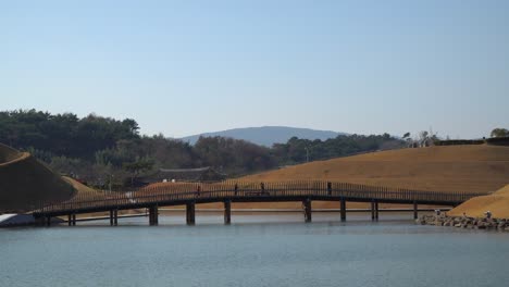 Suncheonman-Bay-National-Garden---Tourists-walking-across-the-Bridge-of-Dreams-over-the-lake,-Suncheon,-South-Korea