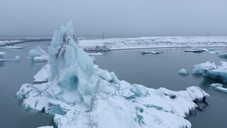 Primer-Plano-Aéreo-De-Un-Enorme-Bloque-De-Hielo-En-El-Lago-Glacial-De-Islandia---Vastos-Icebergs-Derritiéndose-Durante-El-Calentamiento-Global